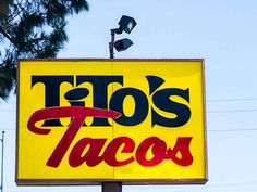 a taco restaurant sign in front of a tree