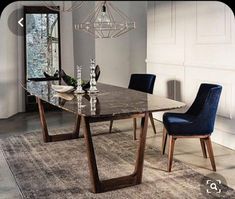 a dining room table with blue chairs and a chandelier