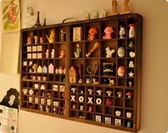 a wooden shelf filled with lots of different types of toy figurines on top of it