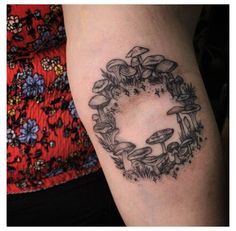 a black and white photo of a woman's arm with a wreath tattoo on it