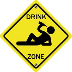 a yellow sign that says drink zone with a person laying on the floor next to it