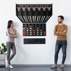 two people standing next to each other in front of a wall with game boards on it