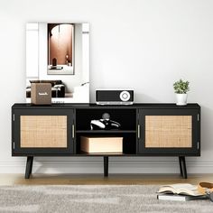 a living room with a black entertainment center and beige rug on the floor next to it