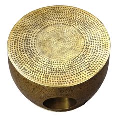 a round metal object with holes in the center on a white background, it appears to be made out of brass