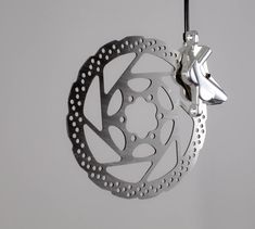 a disc ornament hanging from a hook on a white wall in the shape of a flower