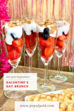 three glasses filled with strawberries, blueberries and cream on top of a wooden table