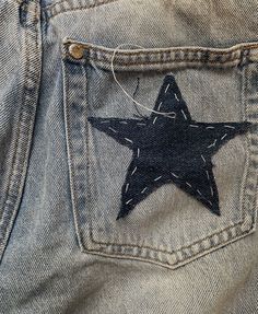 a black and white star is in the back pocket of a pair of jeans