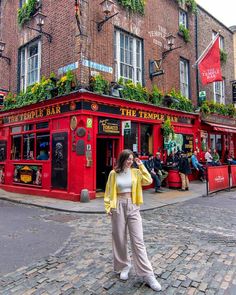 a woman standing in front of a red building