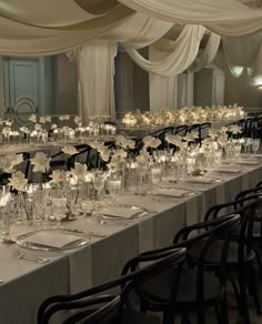 the tables are set up with white flowers and candles