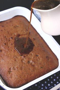 someone pouring syrup on top of a cake in a pan