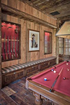 a pool table in a room with wooden walls