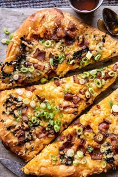 two slices of pizza sitting on top of a pan next to sauces and condiments