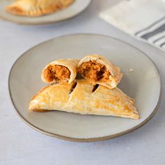 two plates with pastries on them, one has meat in it and the other is filled with fillings