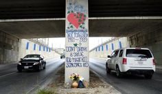 two cars driving under an overpass with graffiti on the wall and flowers in vases