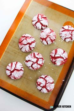 red velvet cookies on a baking sheet covered in powdered sugar are ready to be baked