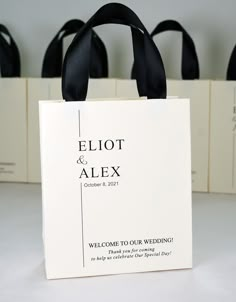 a white bag sitting on top of a table filled with black ribbon and paper bags