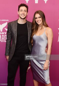 a man and woman standing next to each other on the red carpet at an event