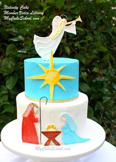 a three tiered cake decorated with an image of a baby jesus and the birth of jesus