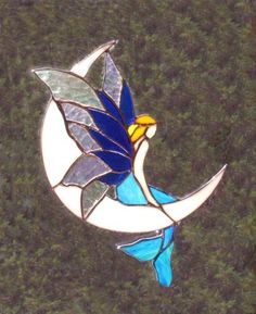 a stained glass bird sitting on the moon