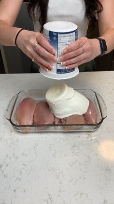 a woman is holding a cup over some food