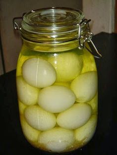 a jar filled with white eggs sitting on top of a table