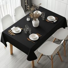 a black table with white plates and silverware