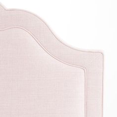 an upholstered headboard with pink linen