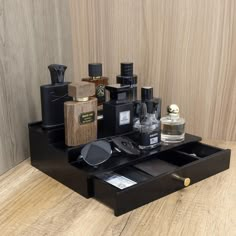 an assortment of perfumes and cologne bottles on a wooden table