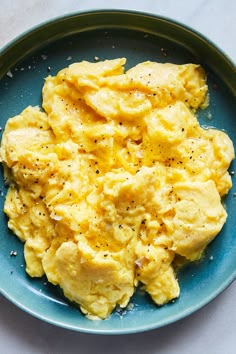 scrambled eggs on a blue plate with seasoning