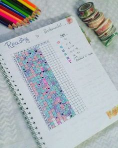 a spiral notebook with some crochet designs and colored pencils next to it