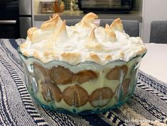 a dessert dish with whipped cream and cookies in it on top of a table cloth