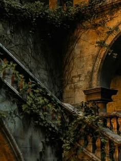 an old building with ivy growing on the side and stairs leading up to it's entrance