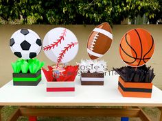 sports themed centerpieces sitting on top of a wooden table in front of a tree