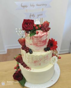 a three tiered cake decorated with berries and flowers