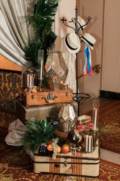 an assortment of hats and other items sitting on top of a suitcase