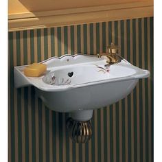 a white sink mounted to the side of a wall next to a striped wallpaper