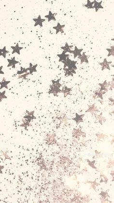 the stars are falling down on the white surface with black and silver sprinkles