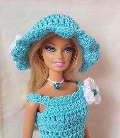 a doll wearing a blue crocheted dress and hat