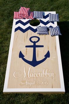 an anchor and chevron ribbon on top of a cornhole board