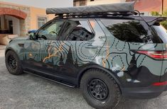 an suv with a surfboard strapped to the roof