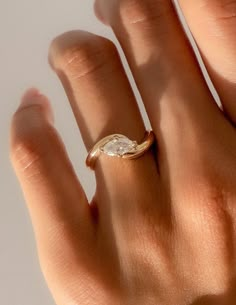 a woman's hand with a gold ring on it and a diamond in the middle