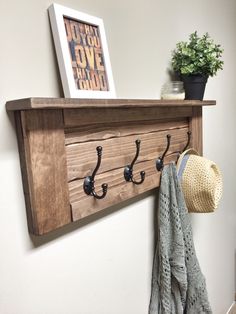 a coat rack with hooks on it and a hat hanging from the wall next to it