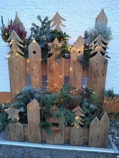 a wooden fence decorated with christmas trees and lights