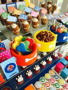 an assortment of cupcakes and treats on display at a dog themed birthday party