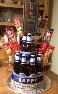 a cake made to look like a happy birthday with beer bottles and snacks on it