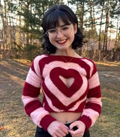 a woman with glasses wearing a red and white knitted heart sweater