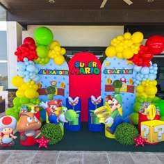 an entrance to a super mario birthday party with balloons and decorations on the front door