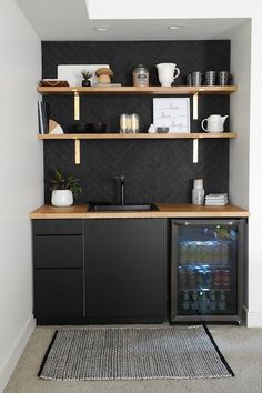 a kitchen area with shelves, cabinets and a rug on the floor in front of it