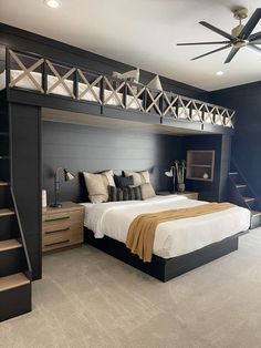 a bed room with a neatly made bed next to a stair case and a ceiling fan