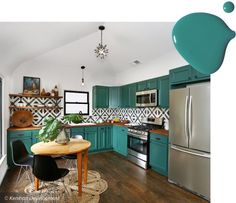 a kitchen with teal cabinets and wood flooring is pictured in this image, there are two chairs at the table